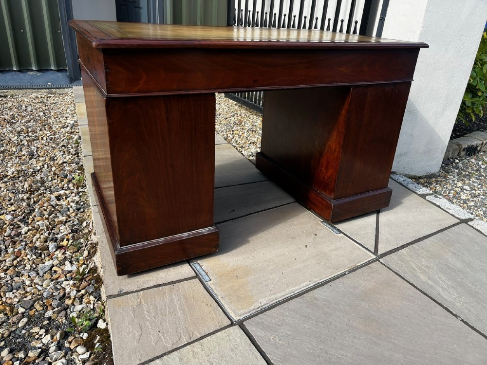 A late 19th-century mahogany pedestal desk featuring nine drawers with brass handles and a plinth base. View IX