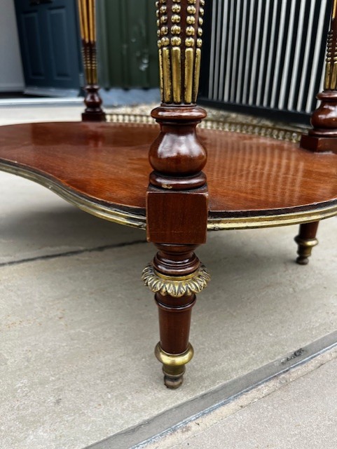 An oval French mahogany vitrine featuring glass side panels, gilt-bronze ormolu mounts, fluted legs, and a gallery top above a lower undertier shelf. View VII
