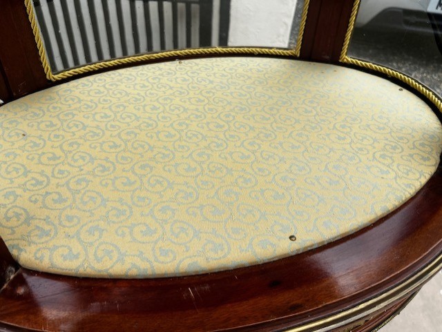 An oval French mahogany vitrine featuring glass side panels, gilt-bronze ormolu mounts, fluted legs, and a gallery top above a lower undertier shelf. View X
