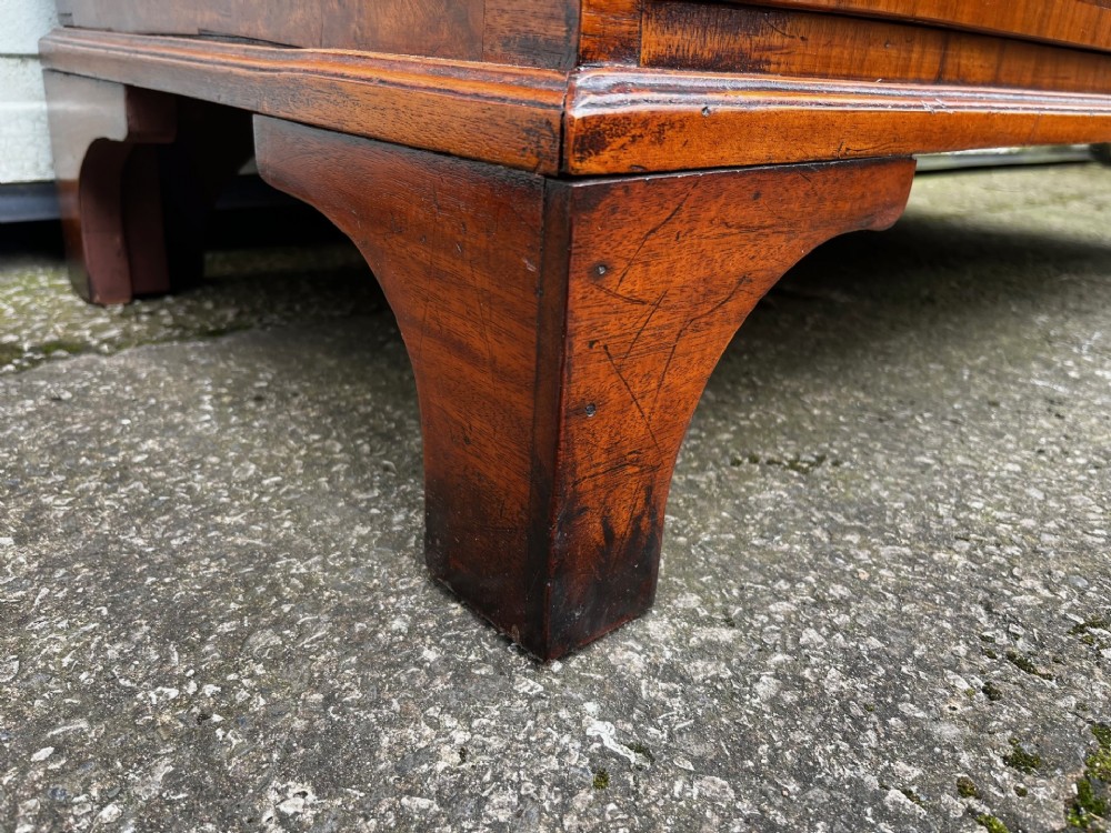 A 19th-century burr walnut veneered chest of drawers featuring two short over three long drawers with brass drop handles and bracket feet. View VIII