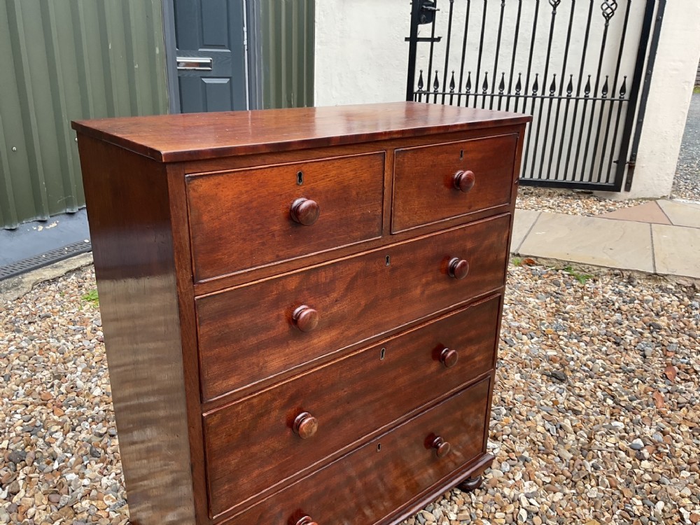 An early Victorian mahogany chest of drawers featuring a two-over-three drawer layout with turned wooden knob handles and short turned feet. View III