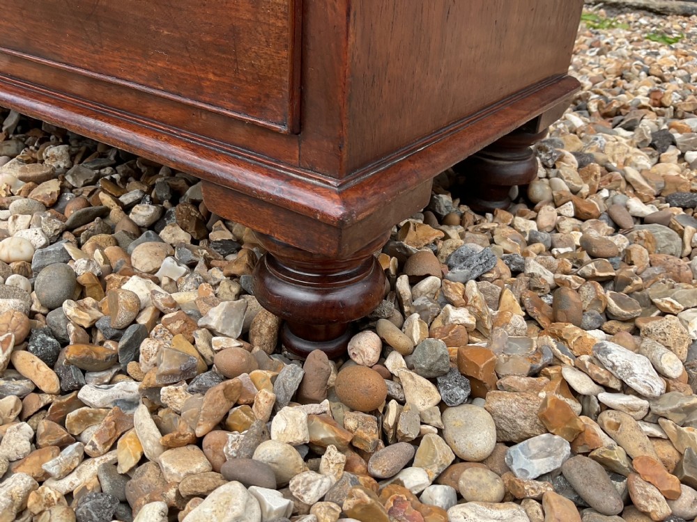 An early Victorian mahogany chest of drawers featuring a two-over-three drawer layout with turned wooden knob handles and short turned feet. View VII