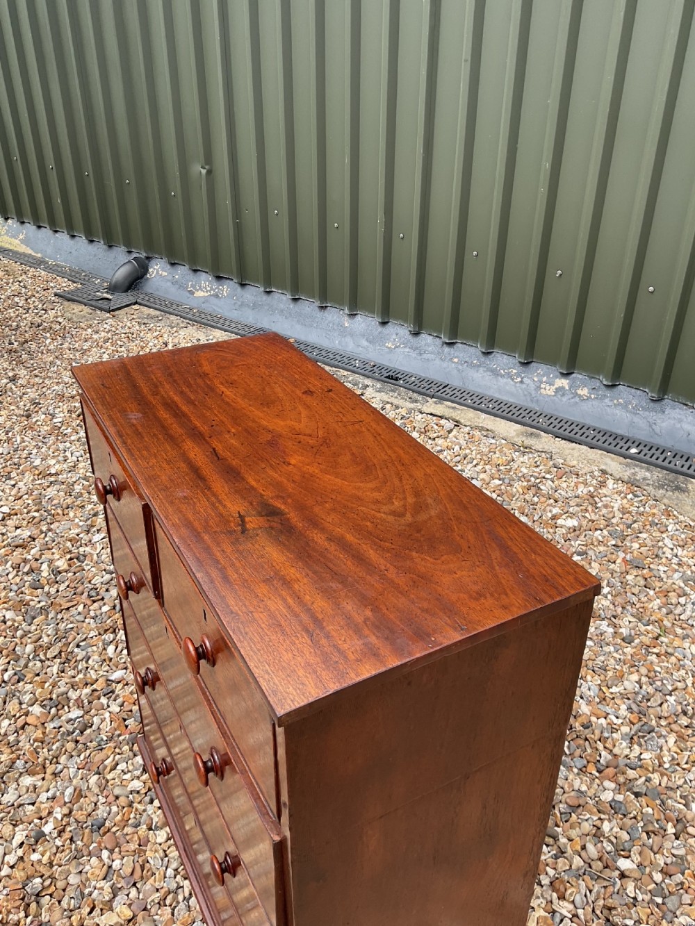 An early Victorian mahogany chest of drawers featuring a two-over-three drawer layout with turned wooden knob handles and short turned feet. View XI