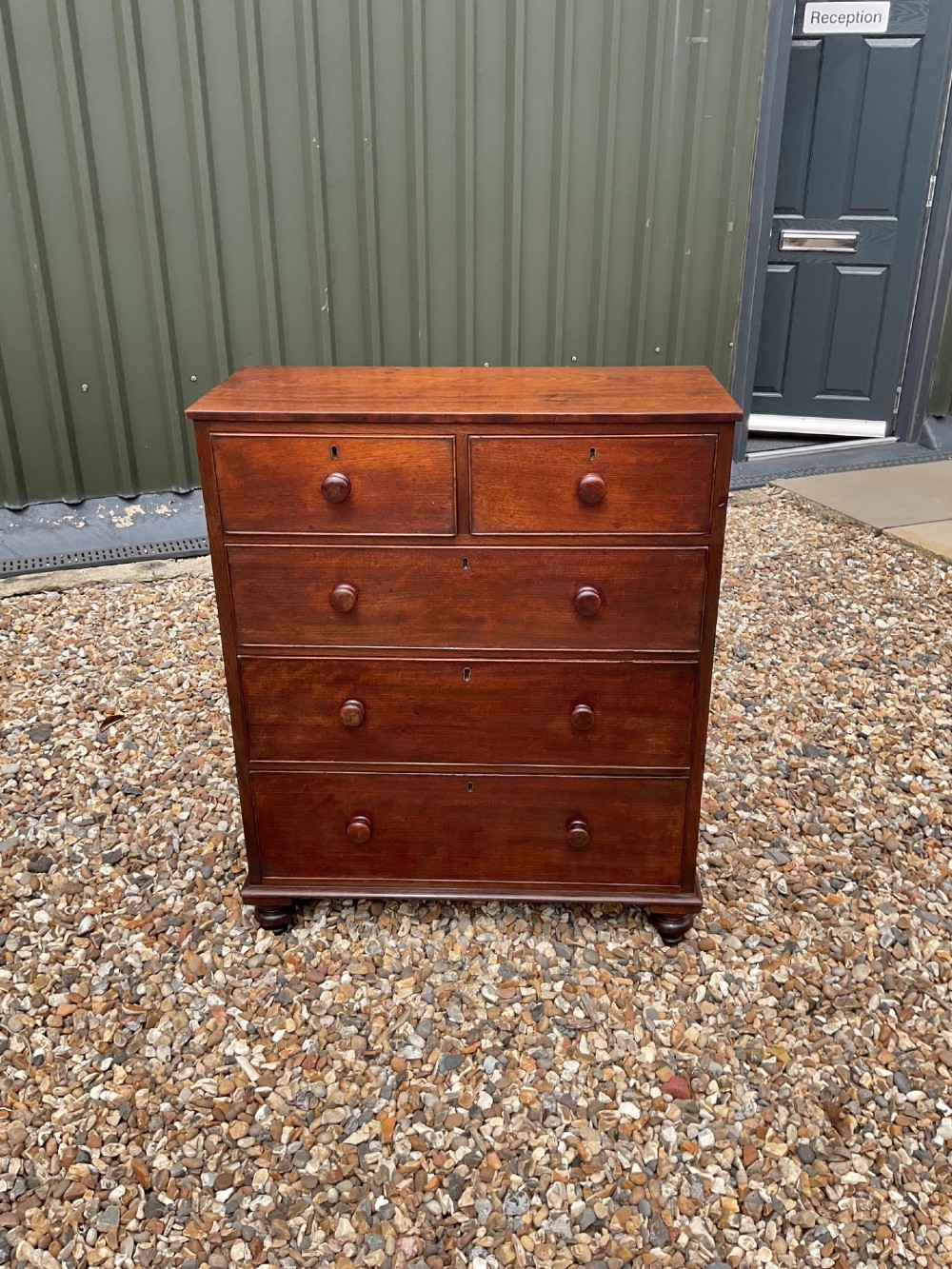 An early Victorian mahogany chest of drawers featuring a two-over-three drawer layout with turned wooden knob handles and short turned feet. View XIII