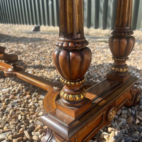 A Victorian burr walnut library table with shaped ends, fluted dual end supports, a low stretcher, and gilded ormolu mounts. View III
