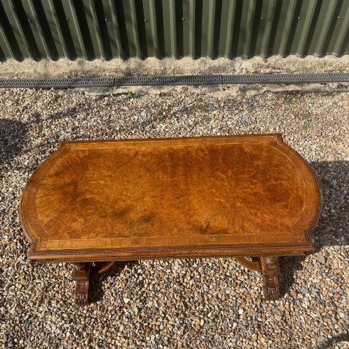 A Victorian burr walnut library table with shaped ends, fluted dual end supports, a low stretcher, and gilded ormolu mounts. View XI