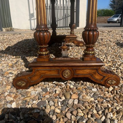 A Victorian burr walnut library table with shaped ends, fluted dual end supports, a low stretcher, and gilded ormolu mounts. View XIII