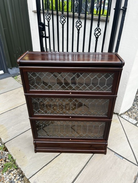 A three-tier Edwardian solid mahogany Globe Wernicke stacking bookcase featuring diamond-leaded glazed doors and a plinth base. View VIII