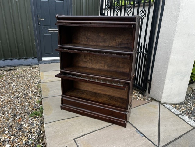 A three-tier Edwardian solid mahogany Globe Wernicke stacking bookcase featuring diamond-leaded glazed doors and a plinth base. View X