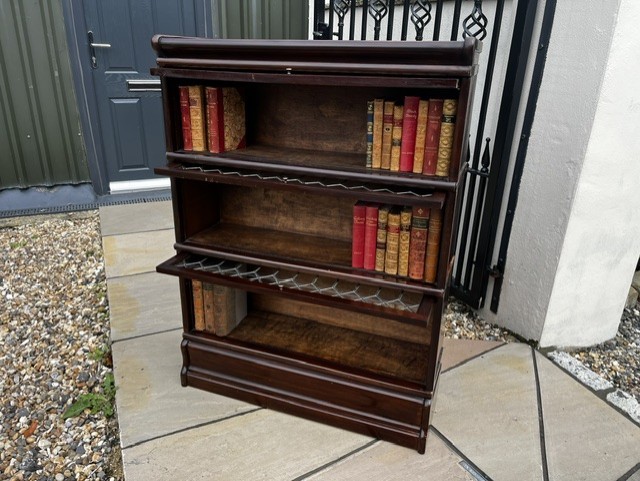 A three-tier Edwardian solid mahogany Globe Wernicke stacking bookcase featuring diamond-leaded glazed doors and a plinth base. View XI