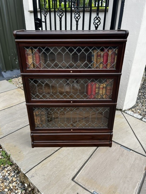 A three-tier Edwardian solid mahogany Globe Wernicke stacking bookcase featuring diamond-leaded glazed doors and a plinth base. View XII