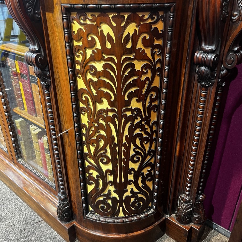 An early Victorian Goncalo Alves and amboyna low bookcase credenza featuring glazed doors and carved corbels. View IV