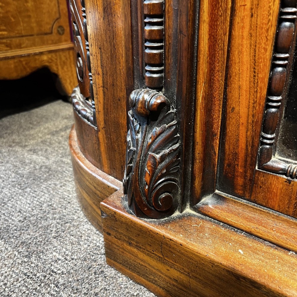 An early Victorian Goncalo Alves and amboyna low bookcase credenza featuring glazed doors and carved corbels. View X