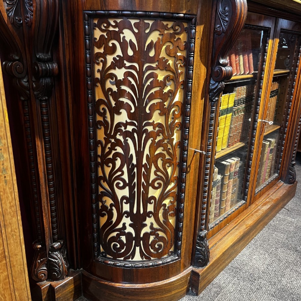 An early Victorian Goncalo Alves and amboyna low bookcase credenza featuring glazed doors and carved corbels. View XIII