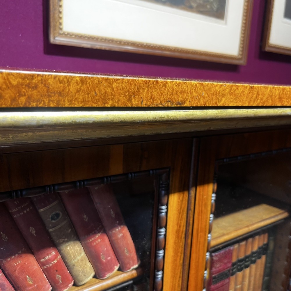 An early Victorian Goncalo Alves and amboyna low bookcase credenza featuring glazed doors and carved corbels. View XIV