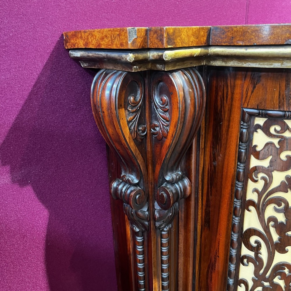 An early Victorian Goncalo Alves and amboyna low bookcase credenza featuring glazed doors and carved corbels. View XV