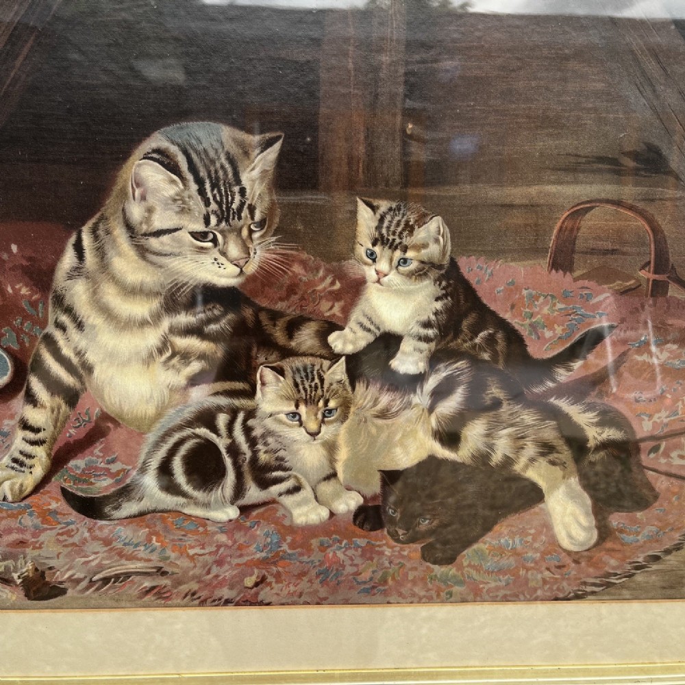 A framed nineteenth-century chromolithograph depicting a mother cat and four kittens resting on a rug, set within a timber frame with a gilt inner slip. View II