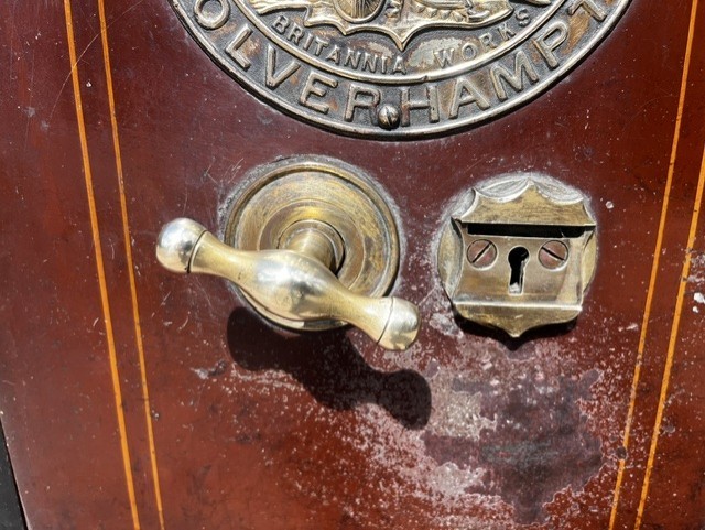 A Victorian cast iron safe featuring a black outer body, maroon door with gold pinstriping, and a round brass Cyrus Price & Co maker badge. View IV