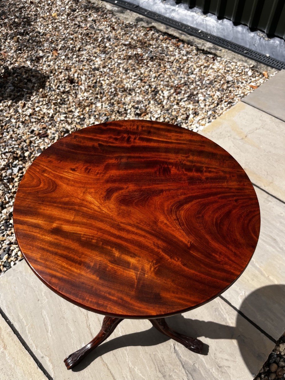 A 19th-century mahogany tripod occasional table featuring a circular polished top, turned central stem, and three carved cabriole legs. View VIII