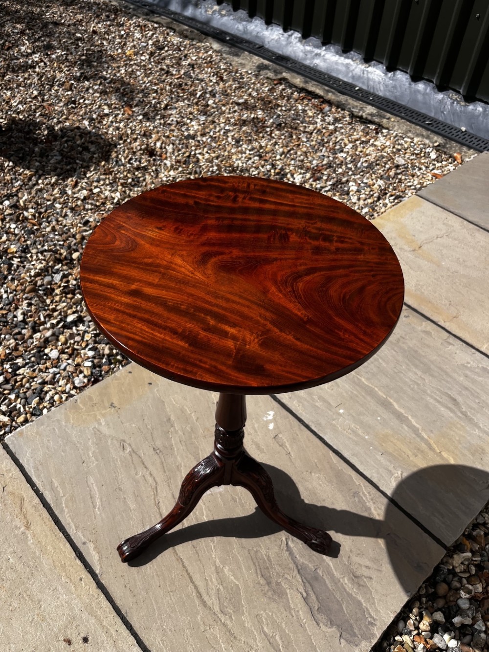 A 19th-century mahogany tripod occasional table featuring a circular polished top, turned central stem, and three carved cabriole legs. View IX