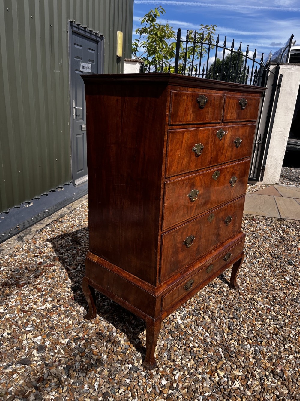 An 18th-century George II walnut chest on stand with brass handles, keyhole escutcheons, and cabriole legs. View X