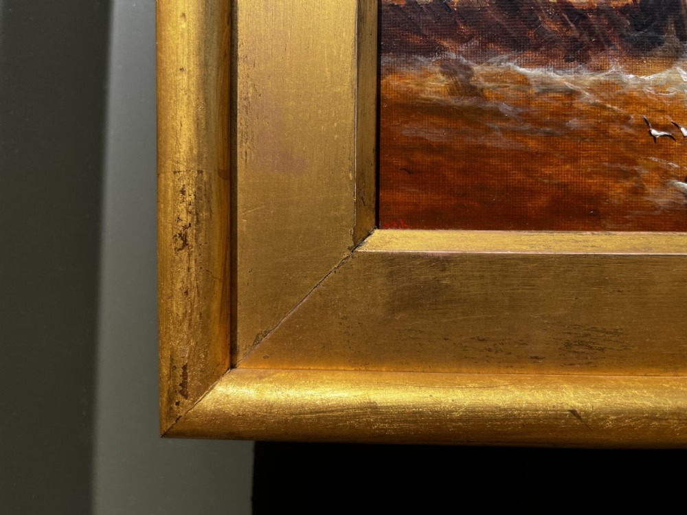 A pair of Victorian marine oil paintings depicting sailing ships on choppy coastal waters, framed in matching gilded rectangular frames with brass nameplates. View X