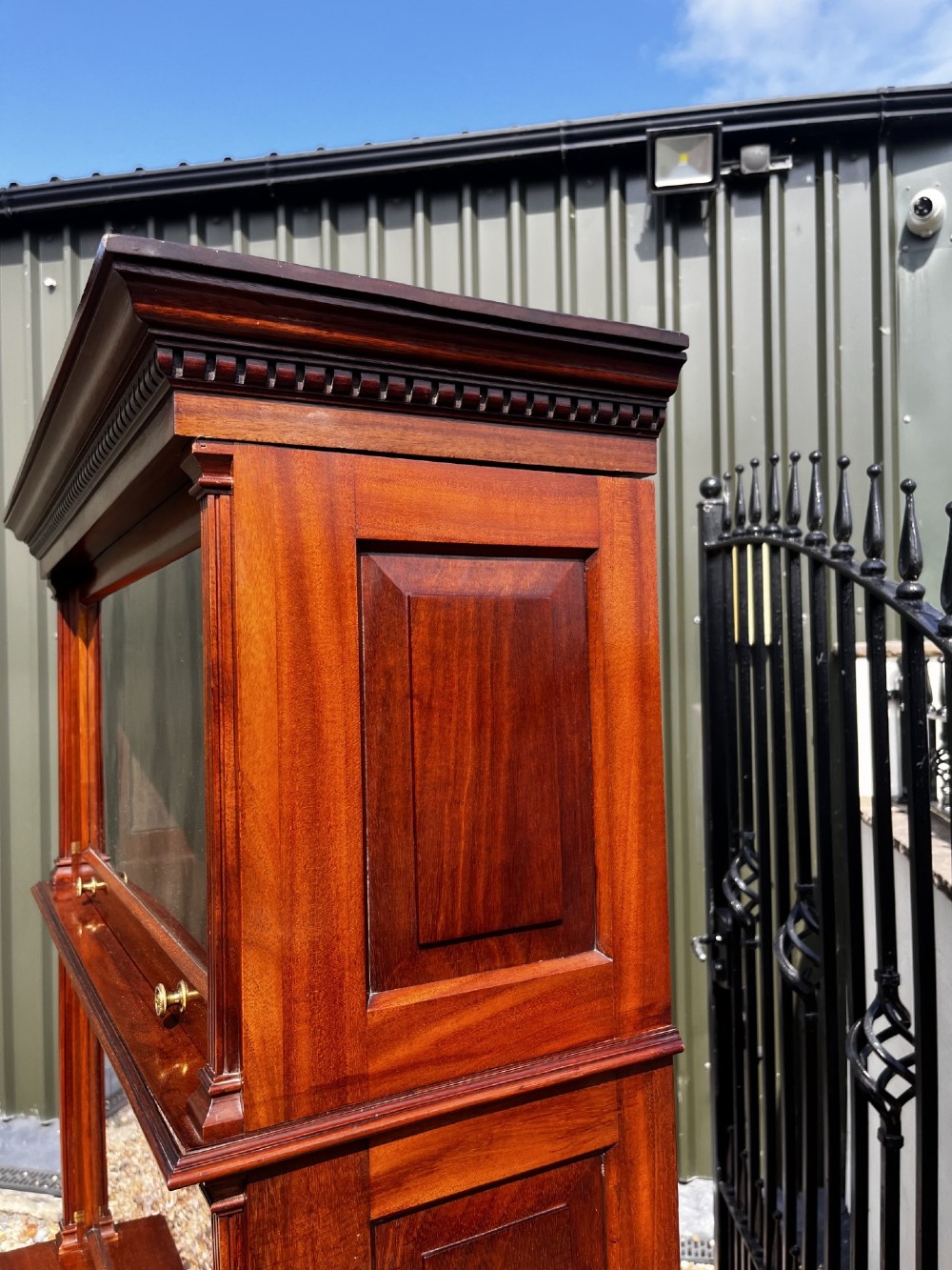 A four-tier solid mahogany barrister stacking bookcase featuring glazed up-and-over doors with brass knobs and a moulded top cornice. View II