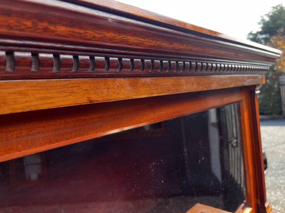 A four-tier solid mahogany barrister stacking bookcase featuring glazed up-and-over doors with brass knobs and a moulded top cornice. View IX
