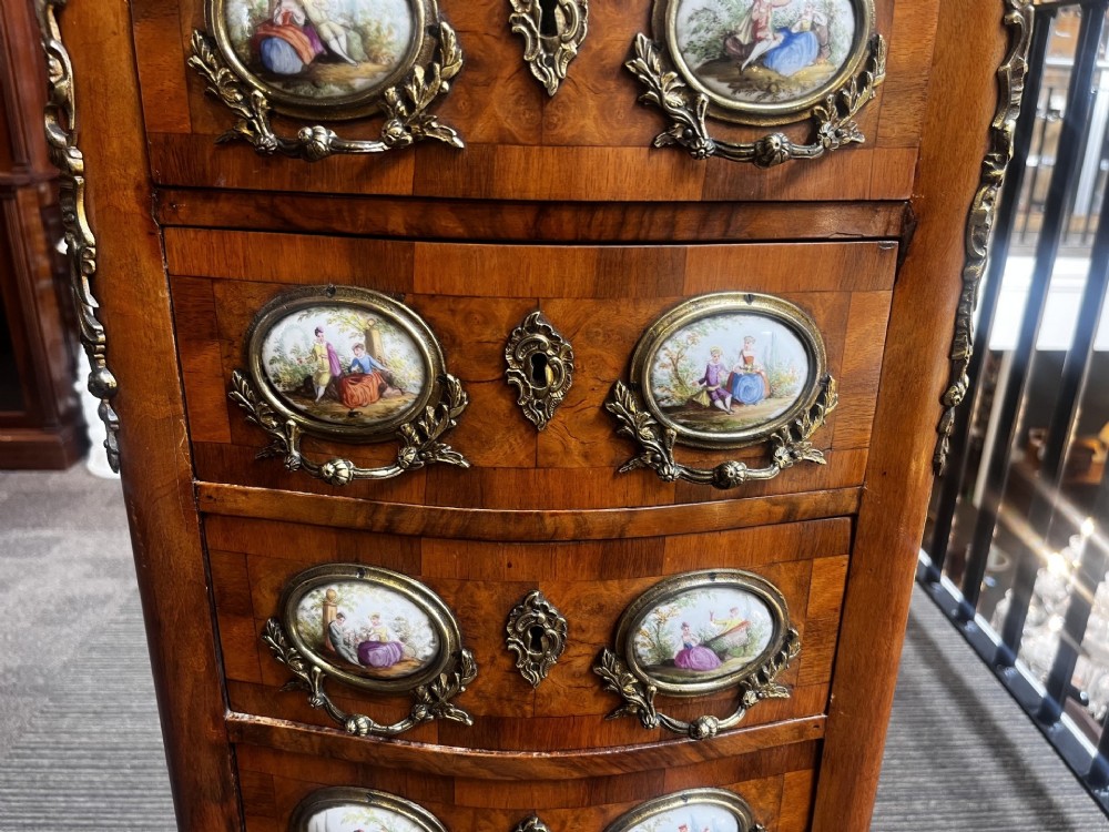 A late nineteenth-century walnut serpentine chest of four drawers featuring hand-painted oval porcelain plaques, ornate metal mounts, and slender cabriole legs. View IV