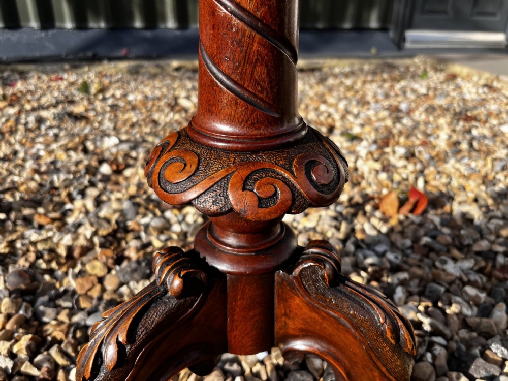 A Victorian burr walnut wine table featuring a scalloped top with floral marquetry inlay, a carved central pedestal, and tripod legs. View III