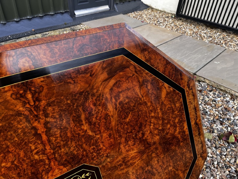 An octagonal Victorian burr walnut low coffee table with central floral marquetry inlay and splayed legs. View IX