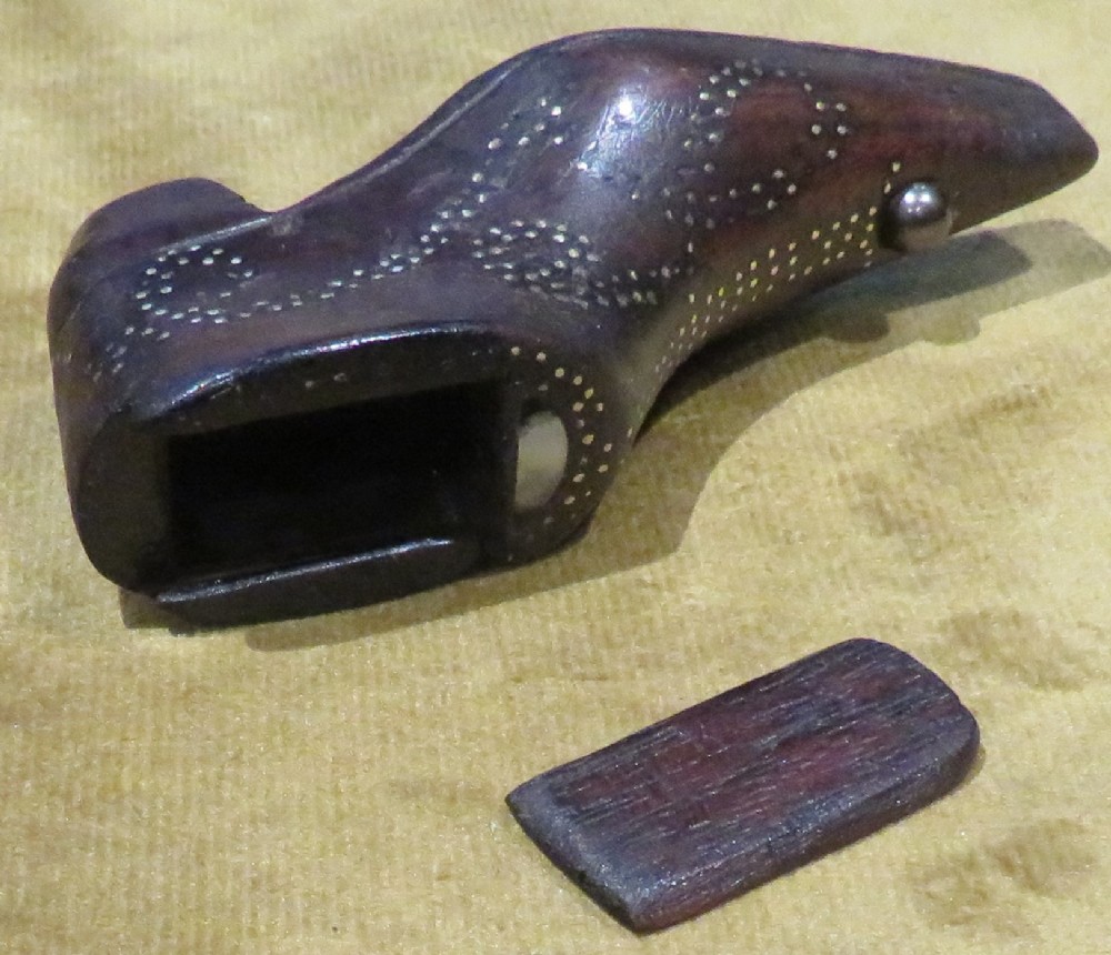 A late Georgian carved dark wood shoe-shaped snuff box featuring decorative brass pique work pin patterns and a removable sliding wooden cover.