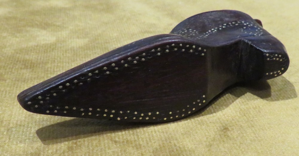 A late Georgian carved dark wood shoe-shaped snuff box featuring decorative brass pique work pin patterns and a removable sliding wooden cover. View IV