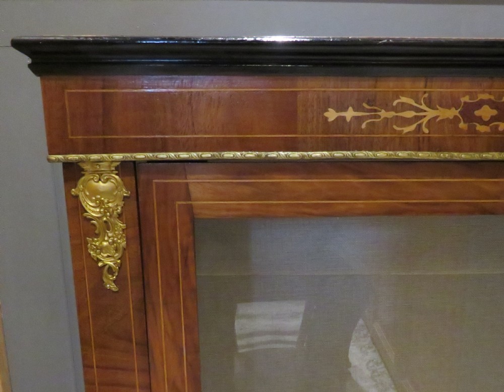 A Victorian walnut pier cabinet featuring a single glazed door, floral marquetry inlay, and gilt brass corner mounts. View III