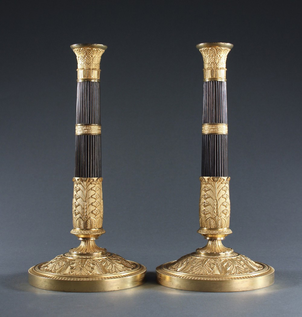 Pair of patinated and gilt bronze reeded column candlesticks