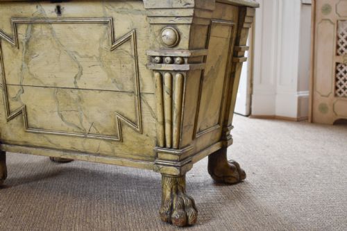 fig 1. A Regency sarcophagus-form cellaret decorated with faux marble painted timber, fluted corner columns, and carved lion paw feet.
