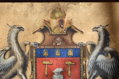 fig 1. A framed 18th-century heraldic artwork displaying a central coat of arms with anvil motifs flanked by two heraldic griffin supporters.