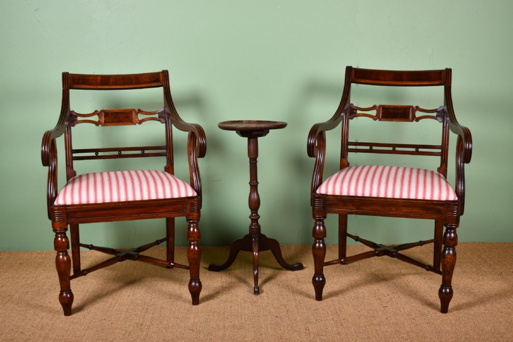 A pair of antique Scottish Regency mahogany armchairs featuring scrolled arms, turned front legs, and pink striped fabric seat cushions. View III