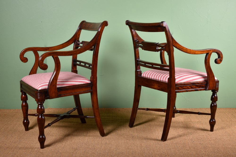 A pair of antique Scottish Regency mahogany armchairs featuring scrolled arms, turned front legs, and pink striped fabric seat cushions. View V