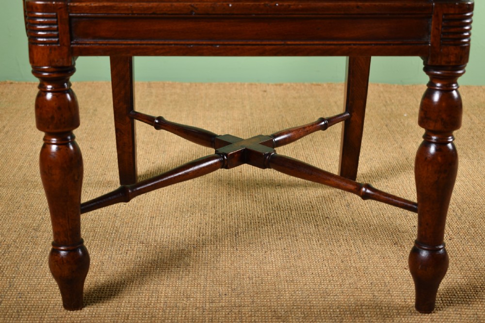 A pair of antique Scottish Regency mahogany armchairs featuring scrolled arms, turned front legs, and pink striped fabric seat cushions. View VI