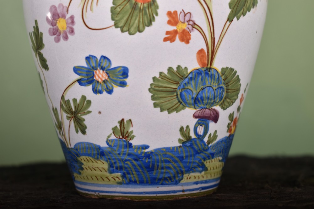 A white tin-glazed earthenware vase featuring hand-painted polychrome Garofano carnation motifs in orange, green, blue, and purple. View III
