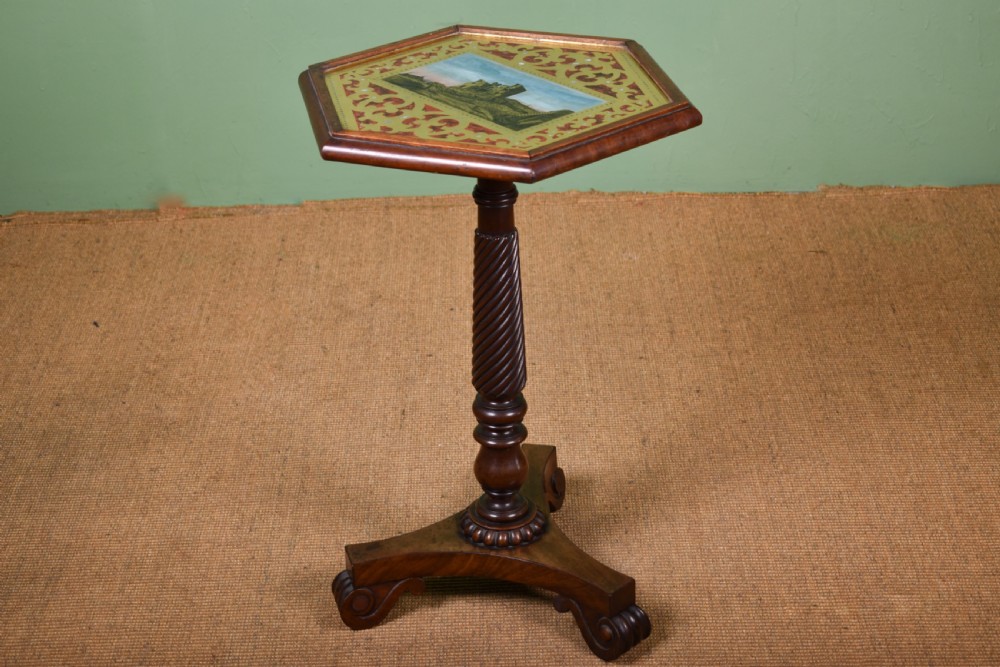 A William IV mahogany side table with a painted hexagonal top, spiral-carved central column, and a triform scroll-foot base.