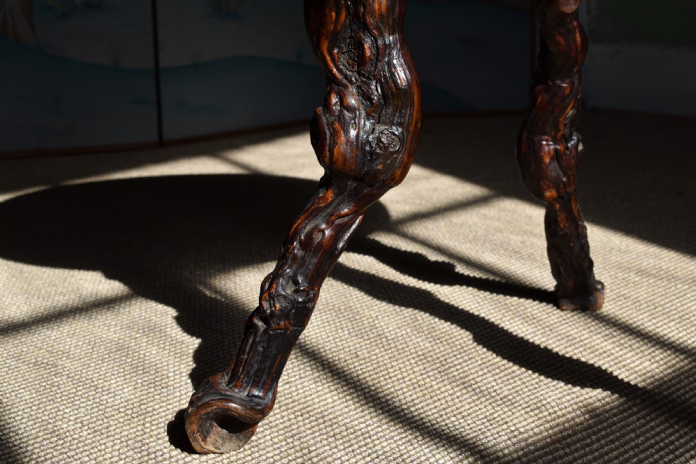 A circular dark wood side table supported by three gnarled and twisted natural grapevine legs. View II