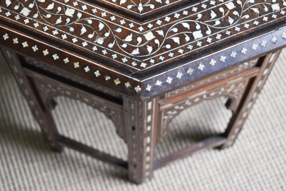 An octagonal dark wood side table featuring intricate bone inlay floral pattern work and decorative arched aprons. View VI