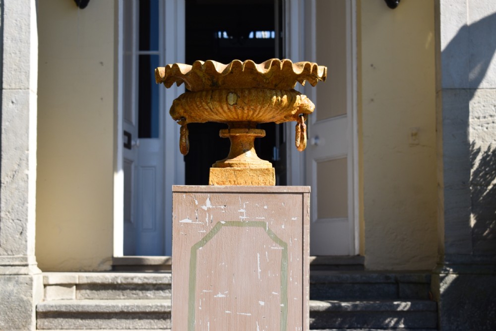 A pair of yellow painted cast iron urns with scalloped rims, gadrooned bodies, and square pedestal bases. View VI