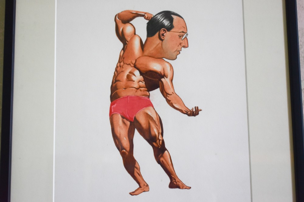 A framed watercolour cartoon depicting a bodybuilder in red trunks flexing his muscles with a caricatured male head. View II