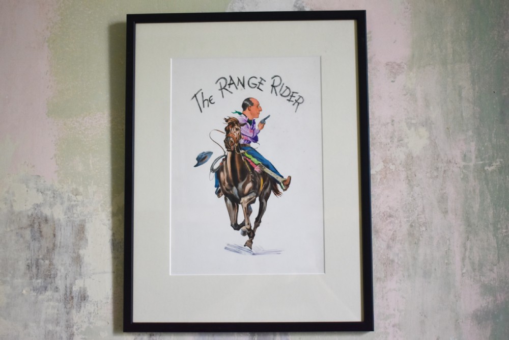 A framed watercolour illustration titled The Range Rider, depicting a caricatured cowboy riding a brown galloping horse on a white background.