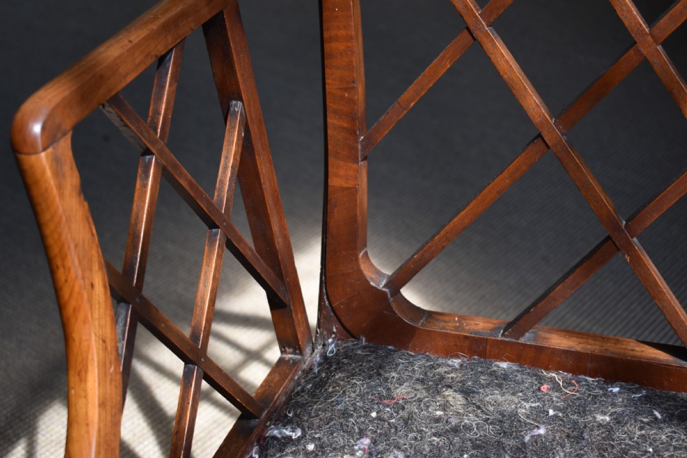 A George III mahogany Cockpen armchair featuring a lattice fretwork backrest, open arms, and a patterned upholstered seat cushion. View II