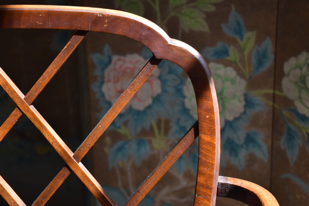 A George III mahogany Cockpen armchair featuring a lattice fretwork backrest, open arms, and a patterned upholstered seat cushion. View III