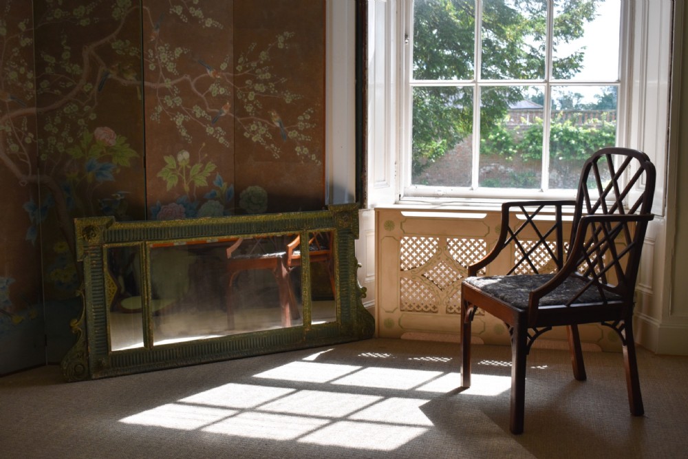 A George III mahogany Cockpen armchair featuring a lattice fretwork backrest, open arms, and a patterned upholstered seat cushion. View V